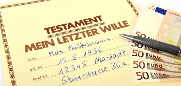 Testament mit Geldscheinen und Stift